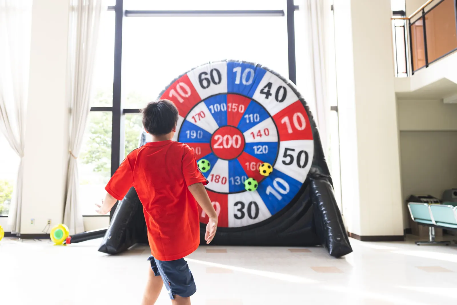 キックダーツ。高さ3mの巨大ダーツ的に向かってボールを蹴る子ども